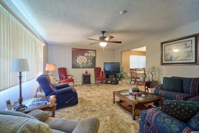living area with carpet flooring, a textured ceiling, and ceiling fan