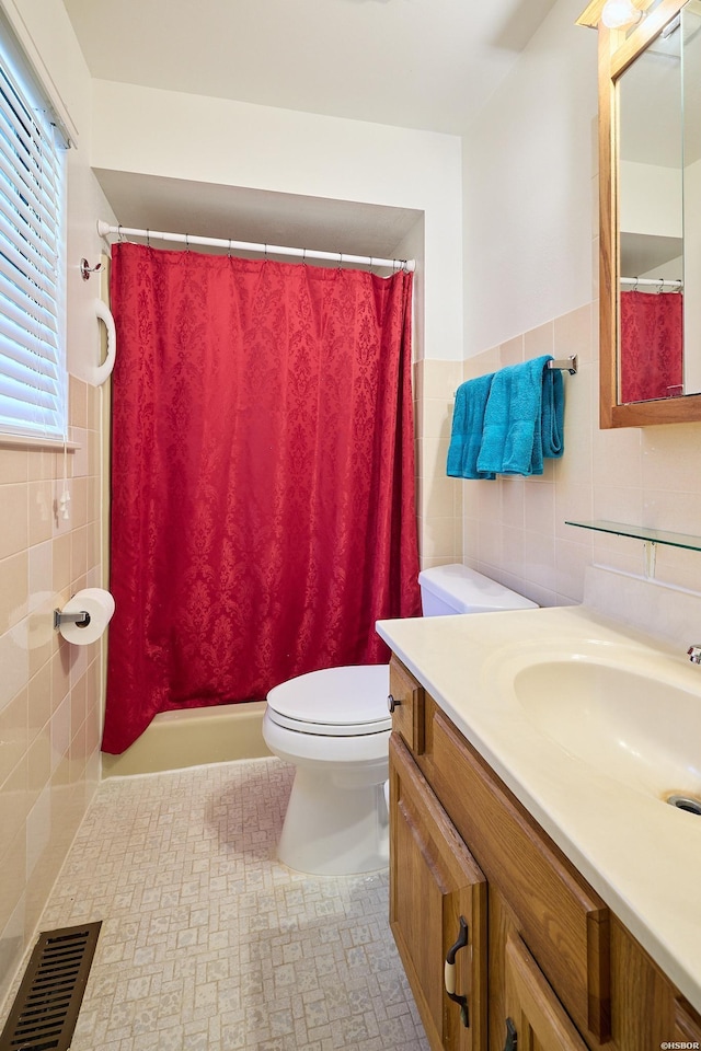 bathroom with tile walls, toilet, a shower with curtain, vanity, and visible vents