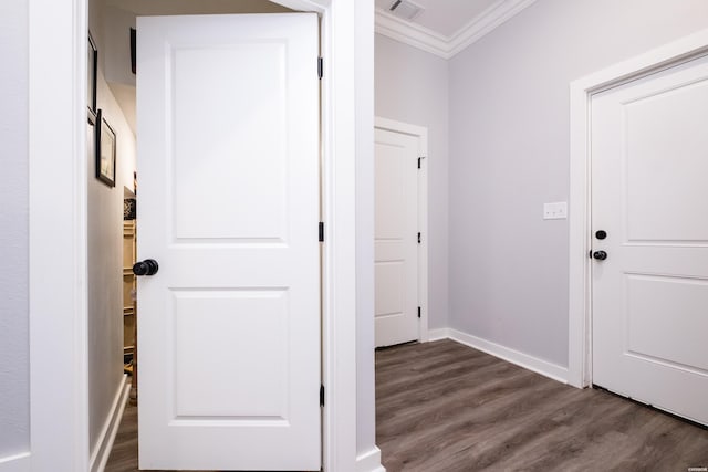 interior space featuring dark wood-type flooring, visible vents, crown molding, and baseboards
