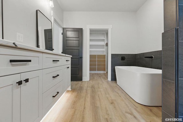 132 Lombard Ct, Hot Springs, AR 71901 - full bath with tile walls, a soaking tub, a walk in closet, vanity, and wood finished floors