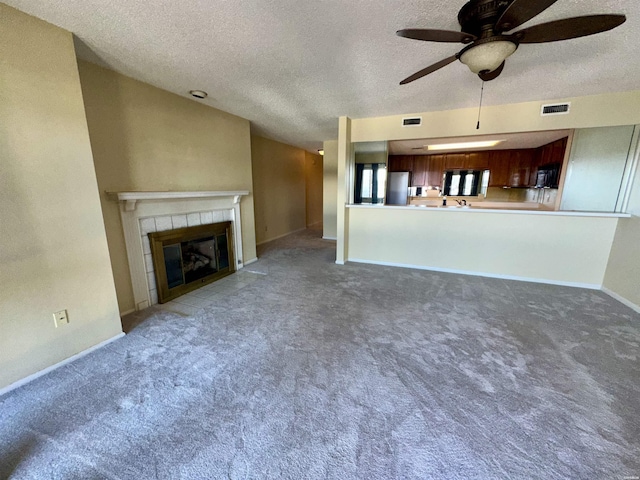 142 Lake Hamilton Dr Unit 410, Hot Springs, AR 71913 - unfurnished living room with carpet, a tiled fireplace, a ceiling fan, and a textured ceiling