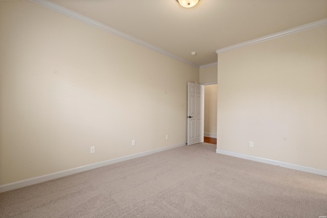 empty room featuring light colored carpet, baseboards, and ornamental molding