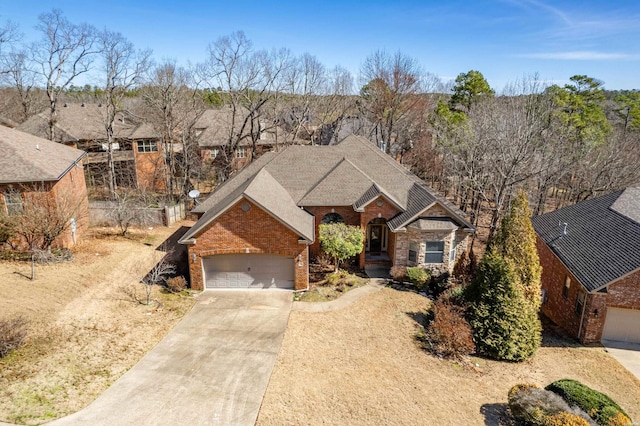 view of front of property featuring concrete driveway, an attached garage, and brick siding