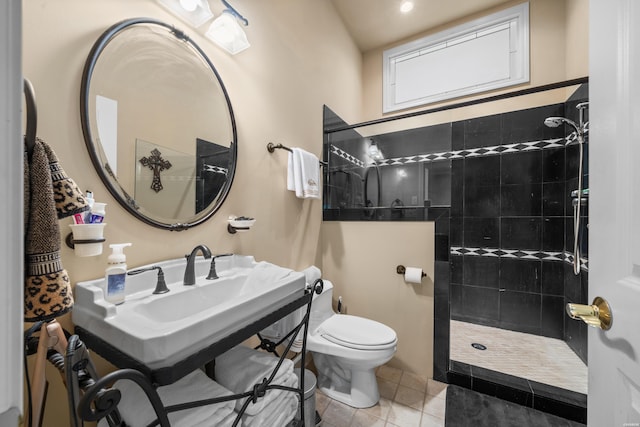 bathroom with toilet, tile patterned flooring, walk in shower, and a sink