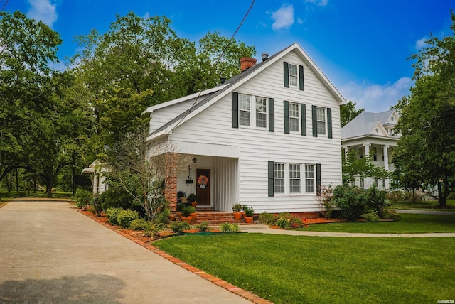 view of front of property with a chimney and a front yard