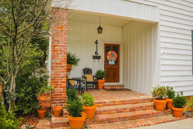 property entrance featuring covered porch and brick siding