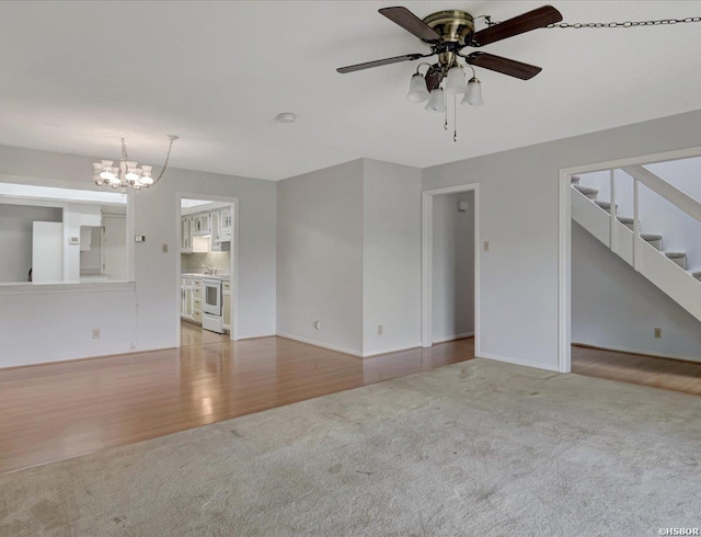 509 Belvedere Dr Unit B4, Hot Springs, AR 71901 - unfurnished living room with light carpet, ceiling fan, a chandelier, stairs, and baseboards