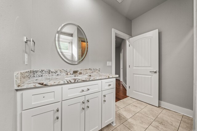 bathroom featuring tile patterned floors, baseboards, and vanity