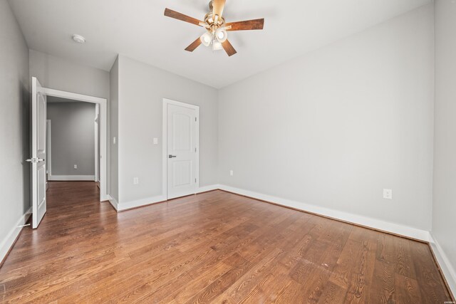 unfurnished bedroom featuring ceiling fan, baseboards, and wood finished floors