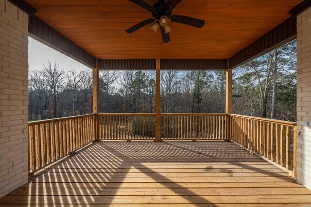 deck with a view of trees and a ceiling fan