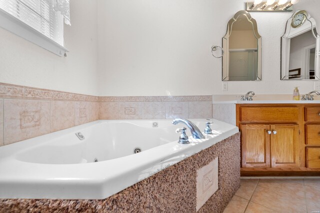 full bathroom featuring a jetted tub, vanity, and tile patterned floors