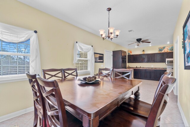 dining room featuring light tile patterned floors, baseboards, visible vents, and ceiling fan with notable chandelier