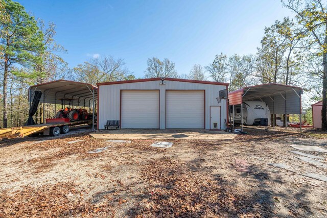 garage featuring dirt driveway and a detached garage