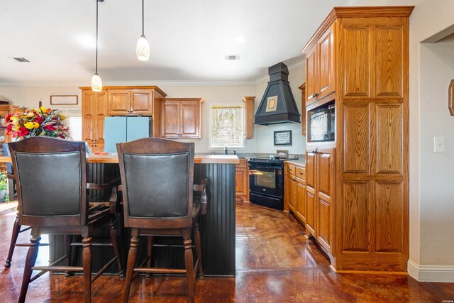 kitchen featuring decorative light fixtures, light countertops, custom range hood, a kitchen island, and black appliances