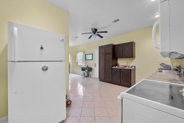 kitchen with white appliances, visible vents, light countertops, a sink, and light tile patterned flooring