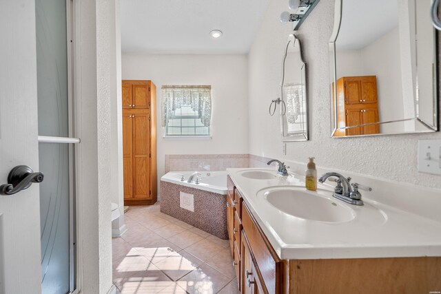 full bath with double vanity, a garden tub, a sink, and tile patterned floors