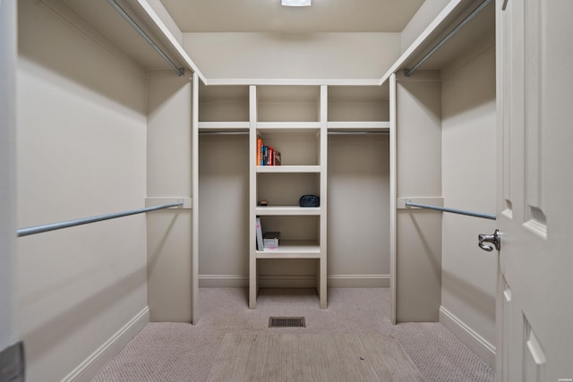 walk in closet featuring light carpet