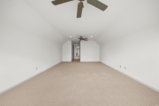 additional living space with light carpet, baseboards, and vaulted ceiling