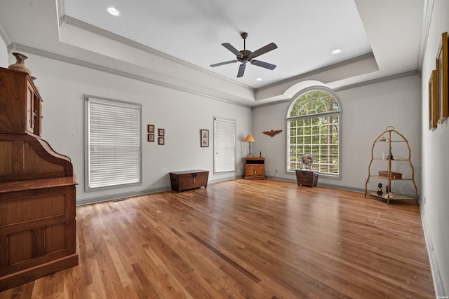 interior space featuring recessed lighting, wood finished floors, baseboards, a raised ceiling, and crown molding