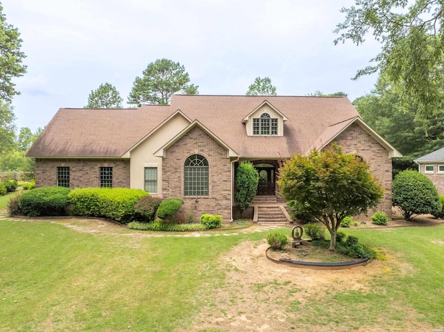 view of front of house with a front lawn and brick siding