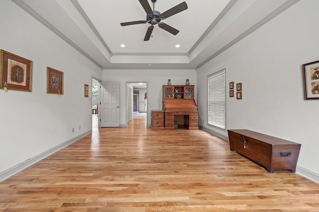 unfurnished living room featuring recessed lighting, baseboards, ornamental molding, light wood-type flooring, and a raised ceiling