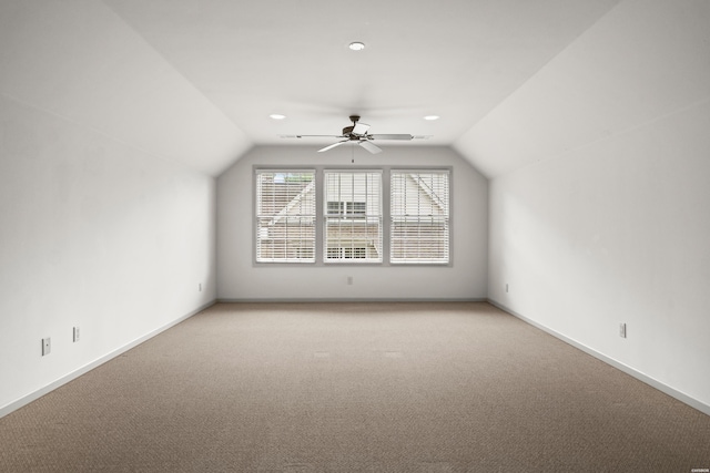 bonus room with lofted ceiling, light carpet, and baseboards