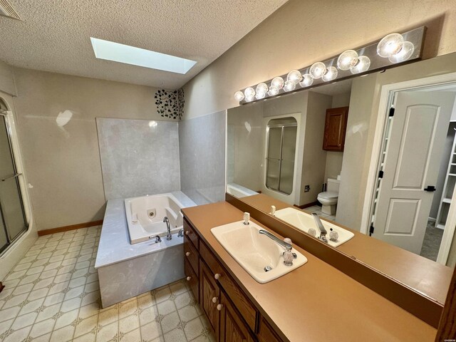 bathroom with a textured ceiling, a garden tub, a skylight, vanity, and a shower stall