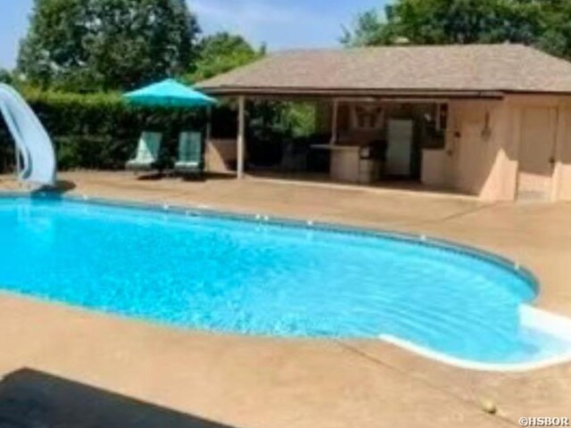 view of pool with a patio and a water slide