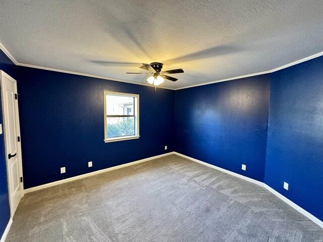 carpeted empty room with a ceiling fan, a textured ceiling, baseboards, and crown molding