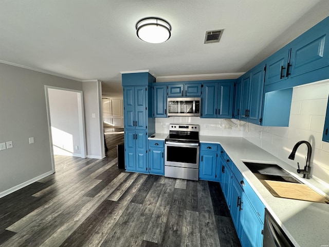 kitchen with blue cabinetry, visible vents, stainless steel appliances, and light countertops