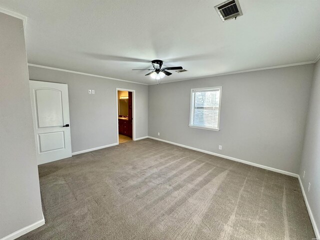 interior space featuring carpet floors, visible vents, crown molding, and baseboards