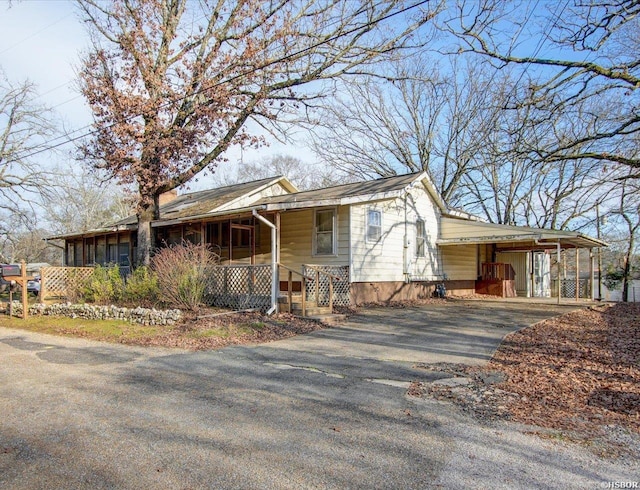 view of front of home featuring a carport, covered porch, and driveway