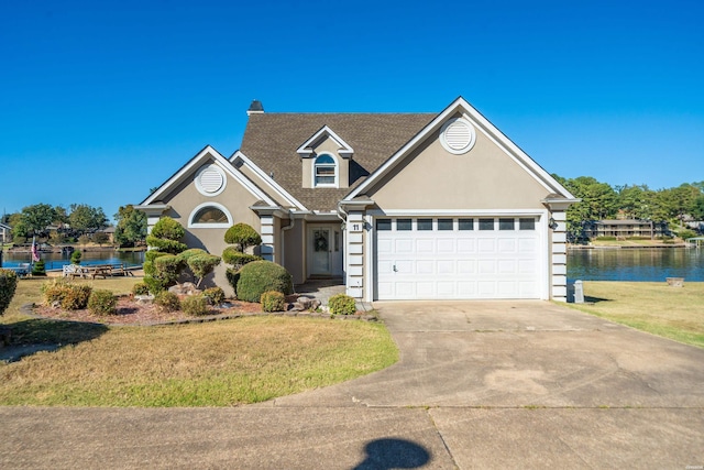 view of front of house with a water view, driveway, a front lawn, and stucco siding