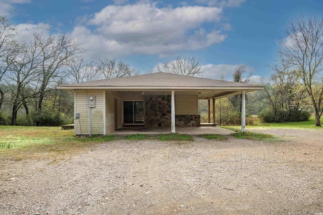 view of front of house with a shingled roof and a carport