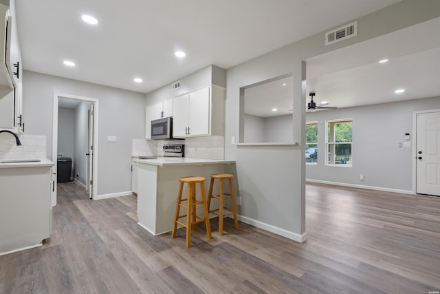401 Buttrum Rd, Royal, AR 71968 - kitchen with stainless steel appliances, a ceiling fan, decorative backsplash, light wood-style floors, and recessed lighting