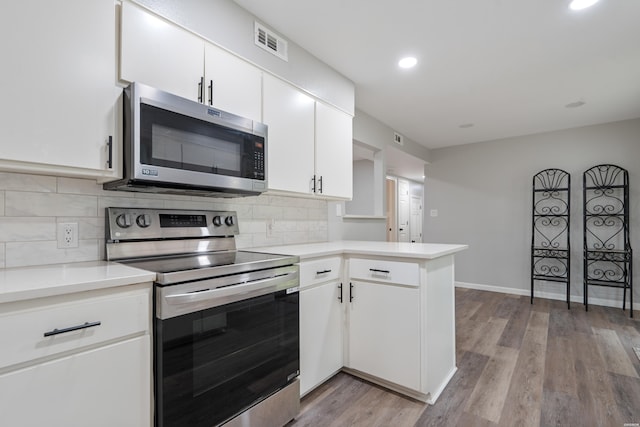 401 Buttrum Rd, Royal, AR 71968 - kitchen with appliances with stainless steel finishes, a peninsula, light countertops, decorative backsplash, and recessed lighting