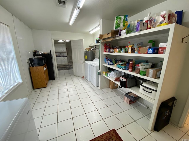 kitchen with light tile patterned floors, visible vents, water heater, open shelves, and washing machine and clothes dryer