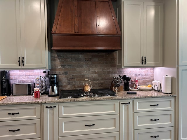 1910 Josh Dr, Conway, AR 72034 - kitchen with range hood, stainless steel gas cooktop, decorative backsplash, and light stone countertops