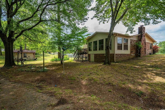 view of side of property featuring a chimney and a yard