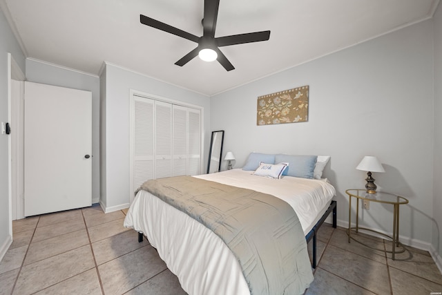 bedroom featuring light tile patterned floors, baseboards, ceiling fan, ornamental molding, and a closet