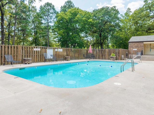 pool with a patio, fence, and an outdoor structure