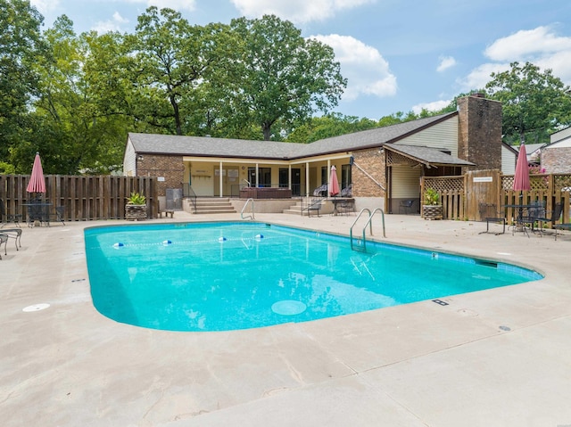 community pool featuring fence and a patio area