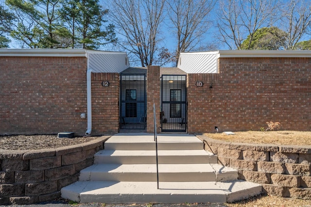 entrance to property featuring brick siding