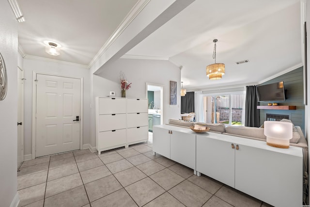 kitchen featuring visible vents, white cabinetry, crown molding, light tile patterned floors, and vaulted ceiling