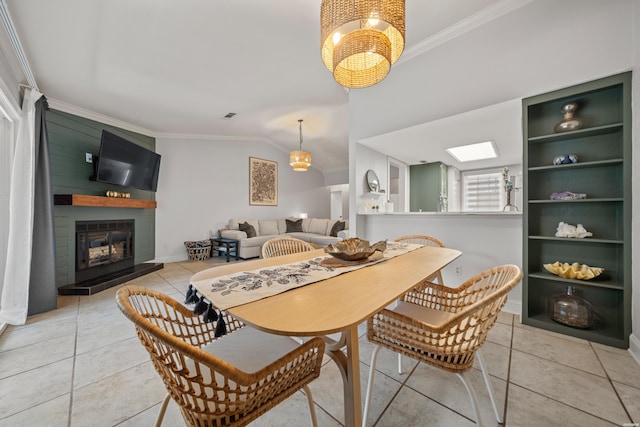 dining area featuring light tile patterned floors, lofted ceiling, and crown molding