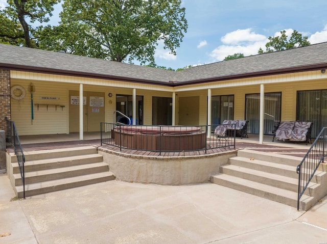 entrance to property featuring a porch and a shingled roof