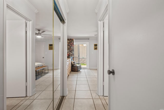 hallway with light tile patterned floors, baseboards, and ornamental molding