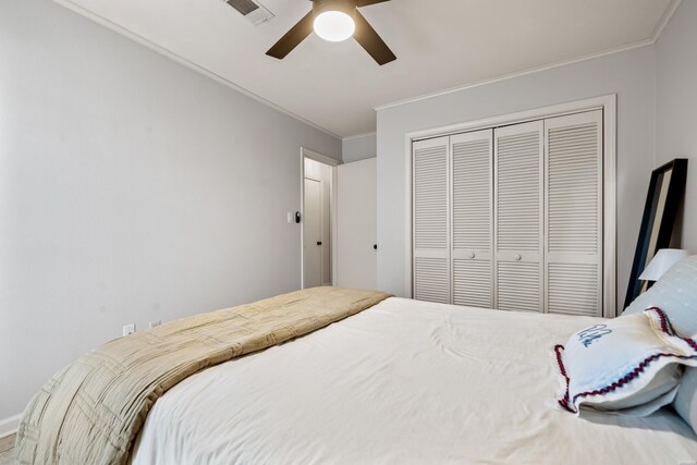 bedroom featuring ceiling fan, visible vents, a closet, and ornamental molding