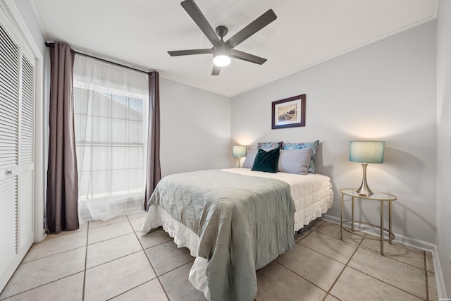 bedroom with light tile patterned floors, baseboards, a closet, and ceiling fan