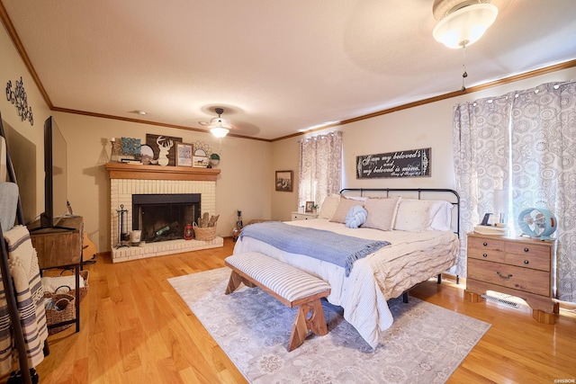 bedroom with crown molding, a fireplace, and wood finished floors